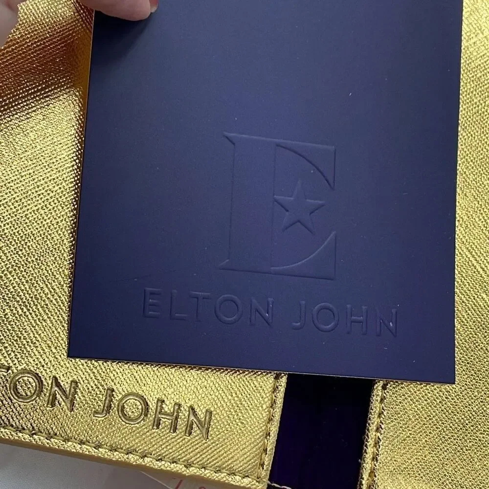 Vintage Elton John gold colored passport cover.